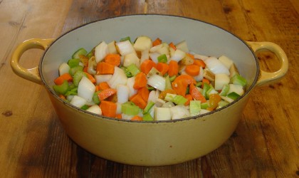 a pot of chopped carrots, celery, onions, potatoes, and green peppers, about to become lentil-vegetable soup