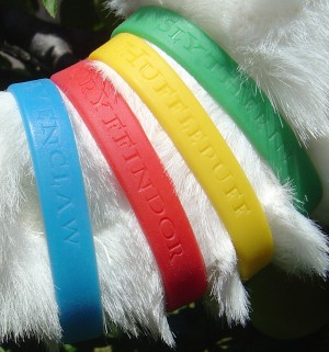 a set of Harry Potter Hogwarts Houses wristbands -- Ravenclaw, Gryffindor, Hufflepuff, and Slytherin -- a Deathly Hallows promotional item