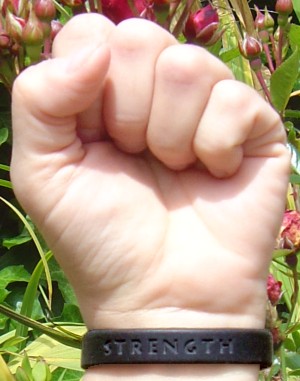 a black 'Strength' wristband